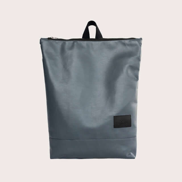 Grey faux leather backpack with zip closure and top handle, ideal for office or casual outings.
