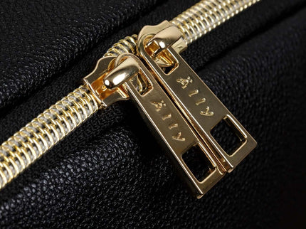 Close-up of a stylish gold zipper on a black backpack, showcasing quality craftsmanship and design.