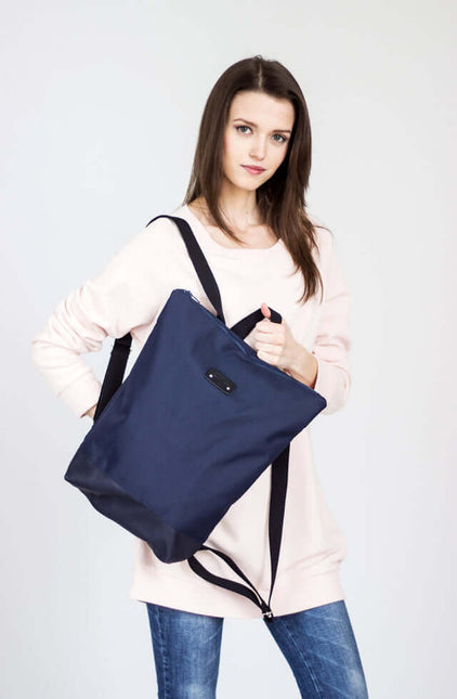 Stylish woman carrying a waterproof backpack with blue leather bottom, perfect for daily essentials.