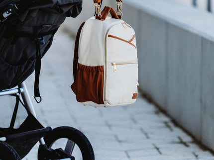 Small diaper backpack in cappuccino color attached to a stroller, showcasing style and convenience for parents.
