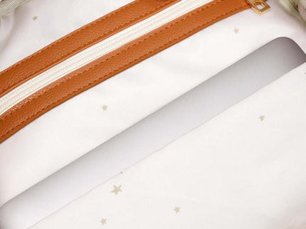 Interior view of a large diaper backpack showing a zipper pocket and light fabric with stars design.