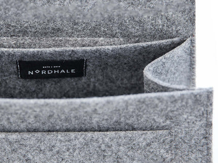 Close-up of the interior pocket of a grey felt backpack featuring the Nordhale logo.