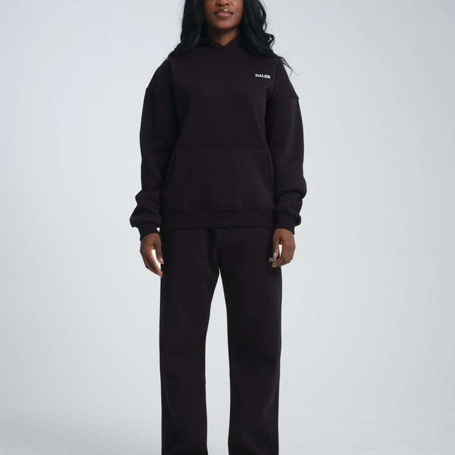 Basic heavyweight black hoodie with DALER embroidery, oversized fit, 80% cotton, worn by a model standing.