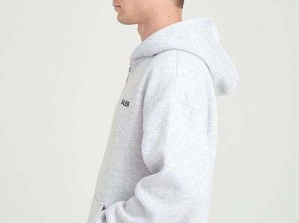 Side view of a male model wearing a grey melange oversized heavyweight zipper hoodie with DALER embroidery.