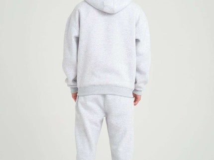 Back view of a model in a grey melange oversized heavyweight zipper hoodie and matching sweatpants.
