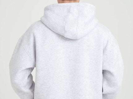 Back view of a model wearing a grey melange heavyweight zipper hoodie, showcasing its oversized fit and cozy design.