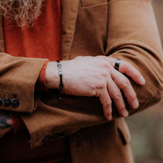 Cody black ceramic bracelet worn with a brown suit