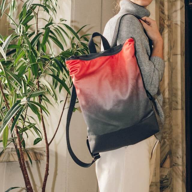 Stylish salmon faux leather backpack with adjustable straps, perfect for daily use.
