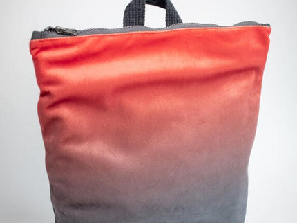 Faux leather backpack with gradient from coral to gray, showcasing its stylish and lightweight design.