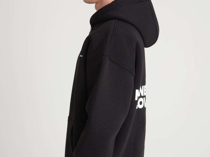 Model wearing heavyweight zipper hoodie with front and back print, showcasing oversized fit and quality design.