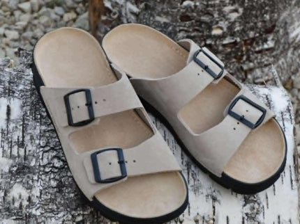Meeliku Women's Leather Sandals in Beige with adjustable buckles on a natural wood background.