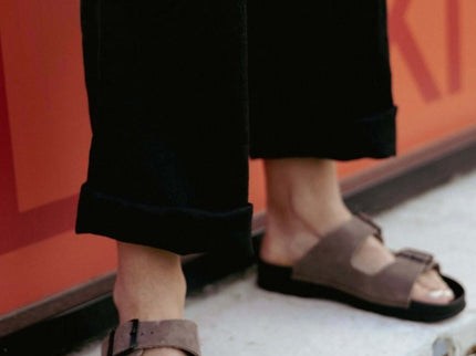 Meeliku women's leather sandals in brown, featuring a stylish design and comfort, worn with black pants.