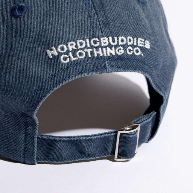 Close-up of the back of a blue denim dad cap by Nordicbuddies featuring embroidered logo and adjustable strap.