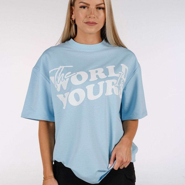 Baby blue oversized T-shirt featuring bold 'The World Is Yours' print, perfect for minimalist streetwear style.